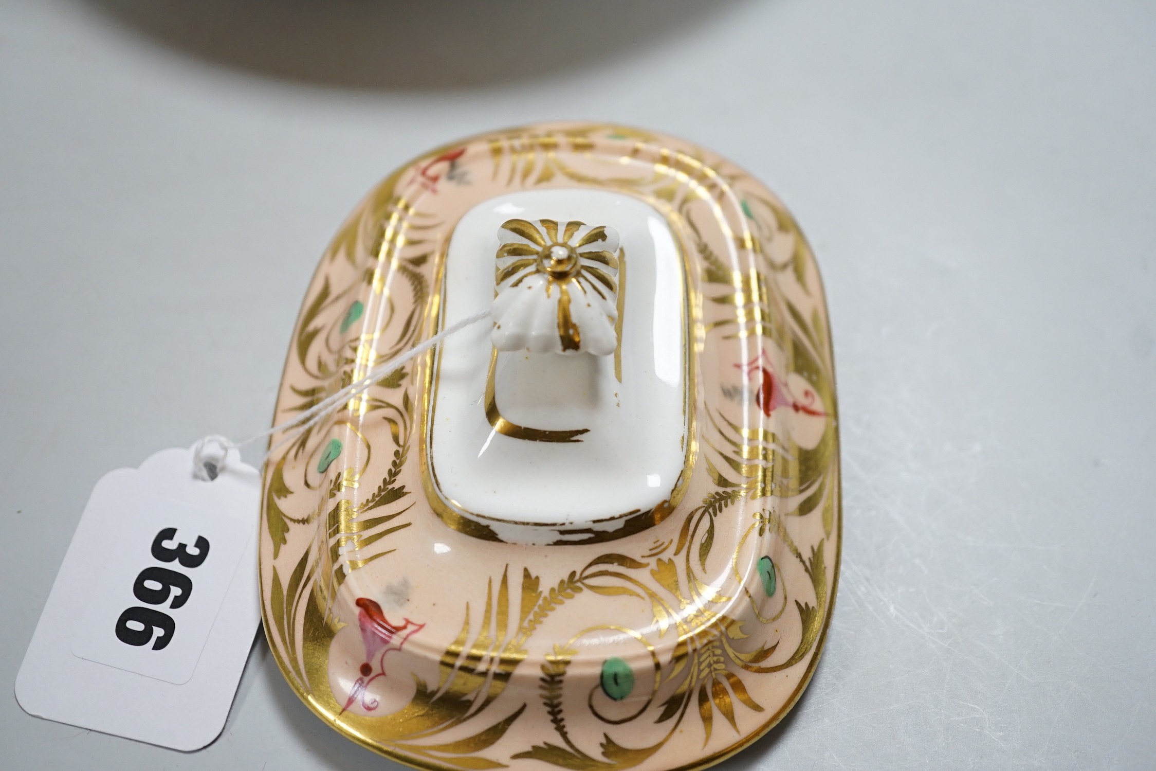 A 19th century Derby sucrier and cover and a matching saucer dish decorated in neo-classical style on a salmon coloured ground, red mark. 15cm tall overall